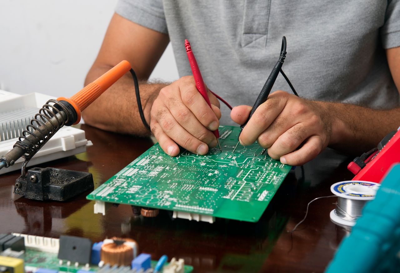 Crafting Captivating Headlines: Your awesome post title goes here Close-up of a technician repairing an electronic circuit board with precision tools.