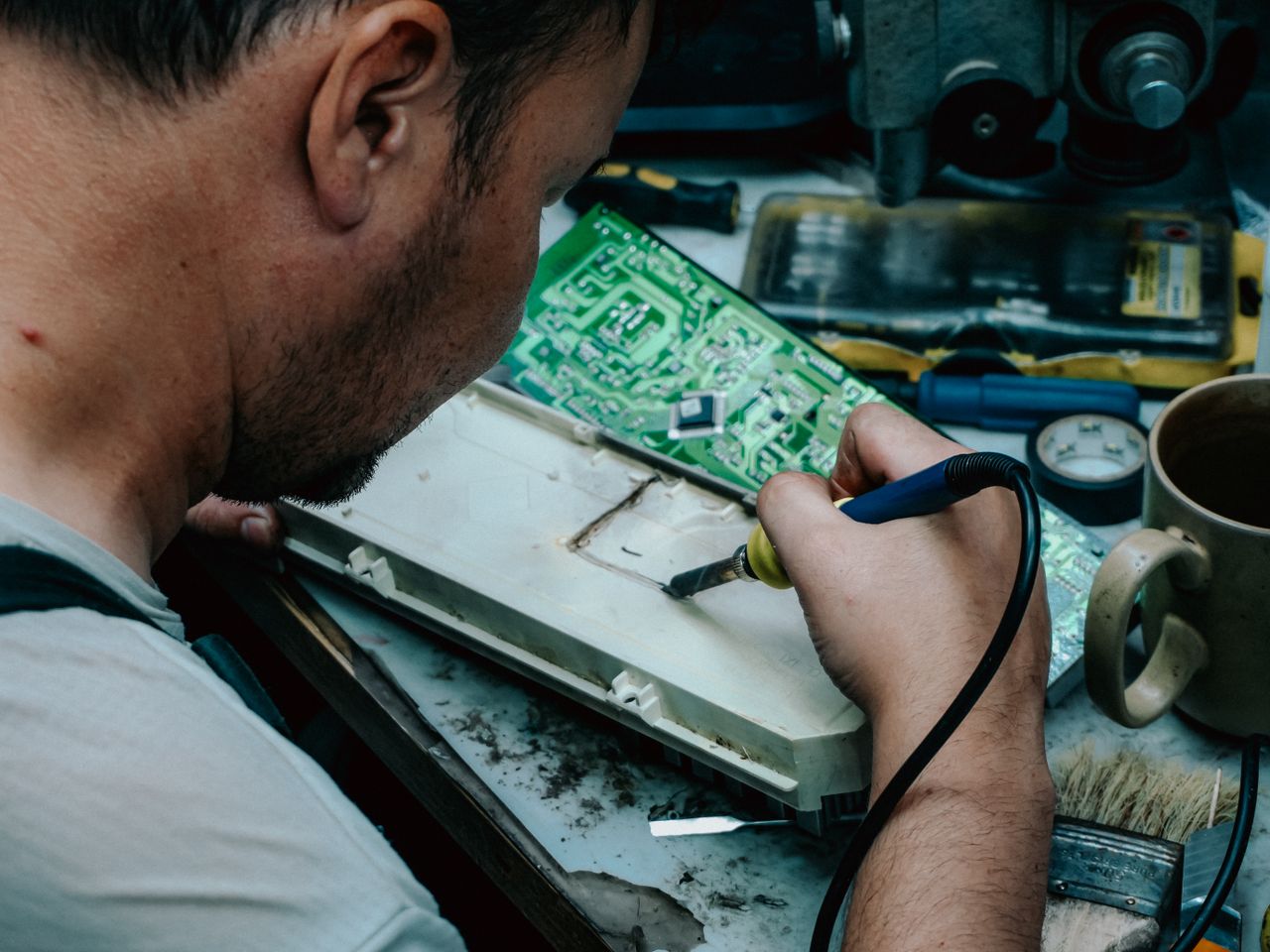 The Art of Drawing Readers In: Your attractive post title goes here A focused technician using a soldering iron to repair electronic components at a workstation.